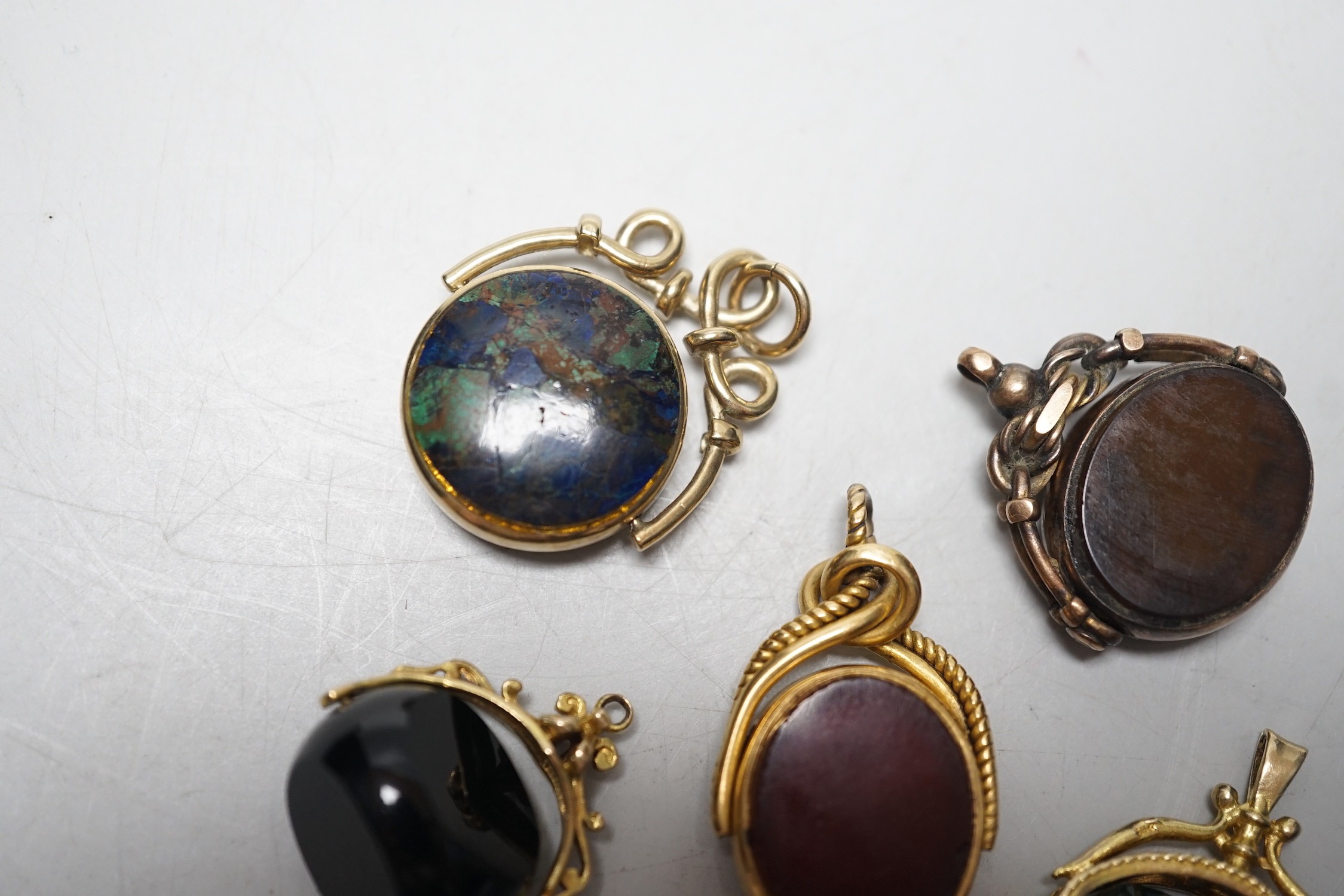 A late Victorian 18ct gold mounted bloodstone and carnelian set spinning fob seal, 36mm, a similar 9ct seal, a yellow metal and turquoise set fob seal and two later 9ct gold mounted seals.